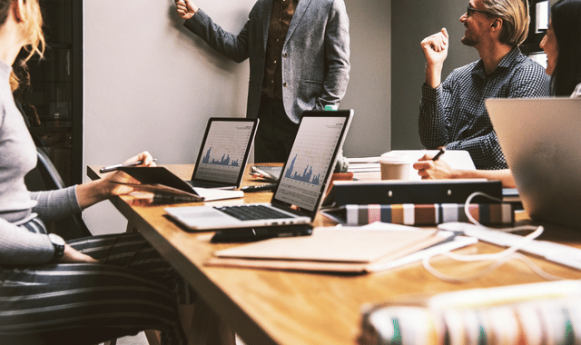 Business professionals reviewing channel incentive program analytics and performance metrics